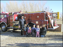 Children and fireman standing in front of fire engine