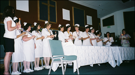 LVN graduates holding lamps during lighting ceremony